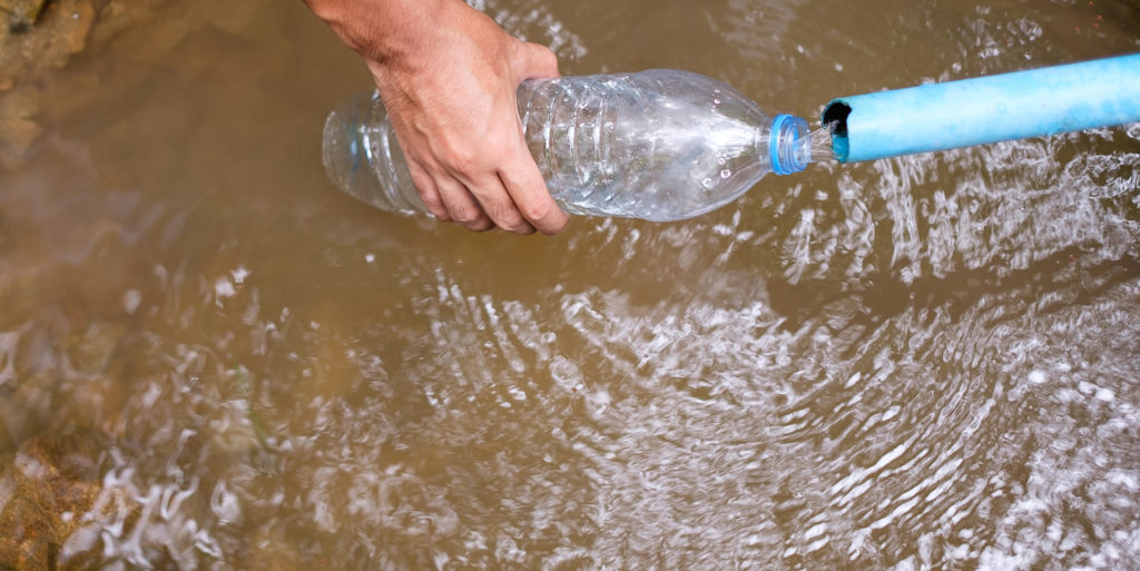 water bottle being filled with dirty water